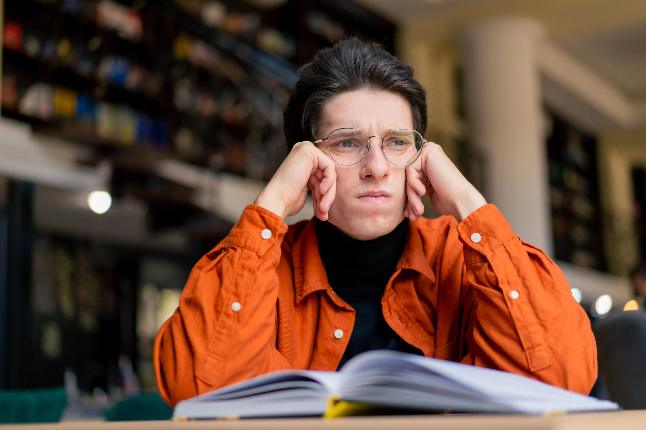 Student looking frustrated while reading a textbook, representing low engagement with static learning materials