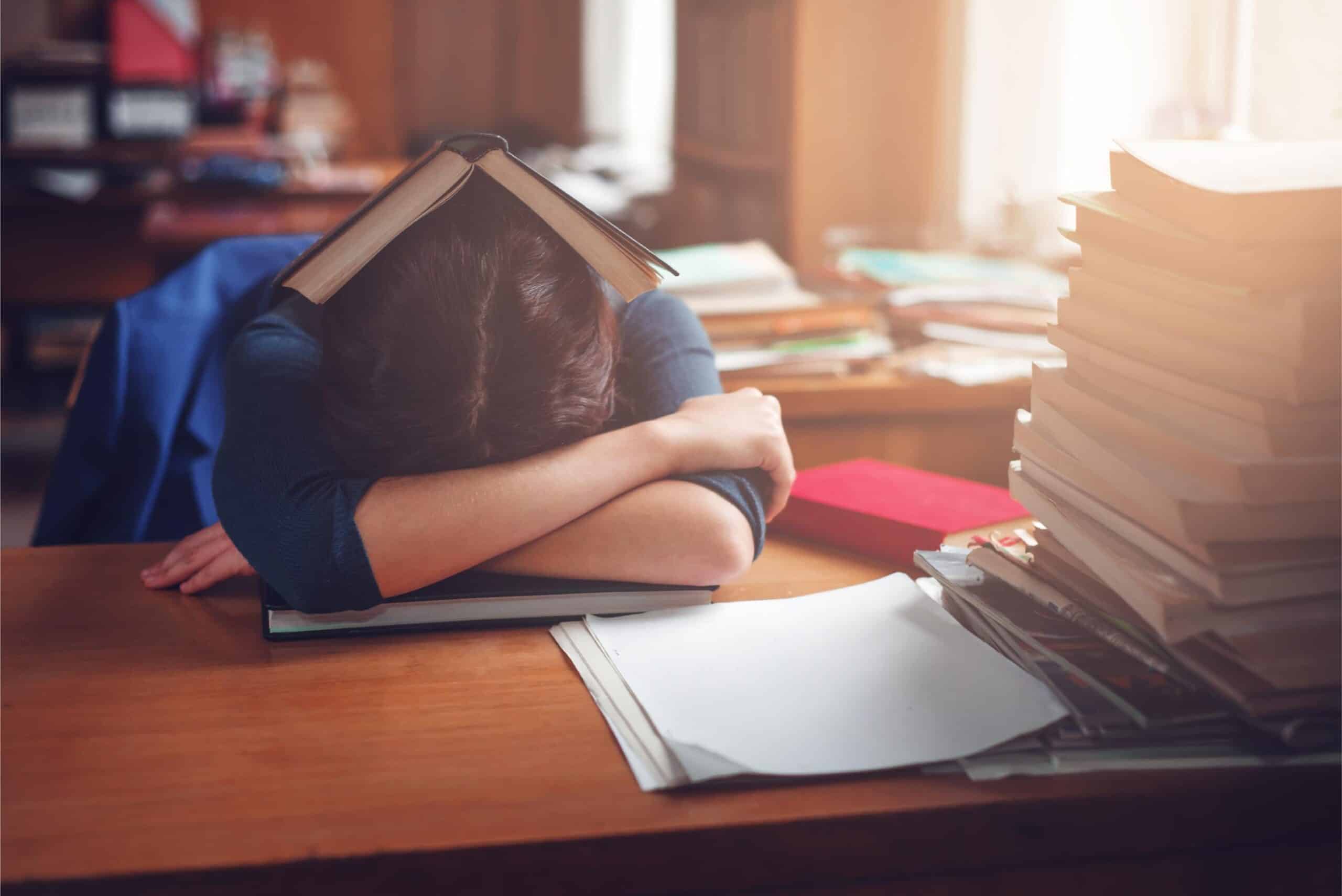 Student overwhelmed by studying materials, representing disengagement in traditional learning
